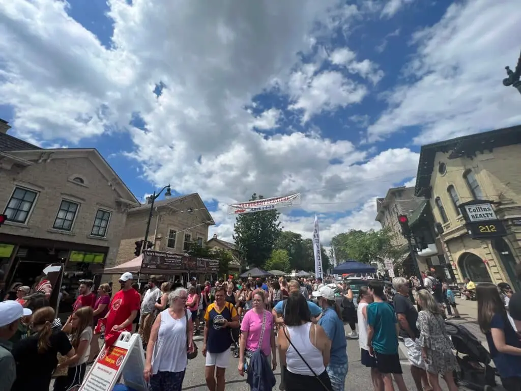 People walking and an overhead banner with words Strawberry Festival