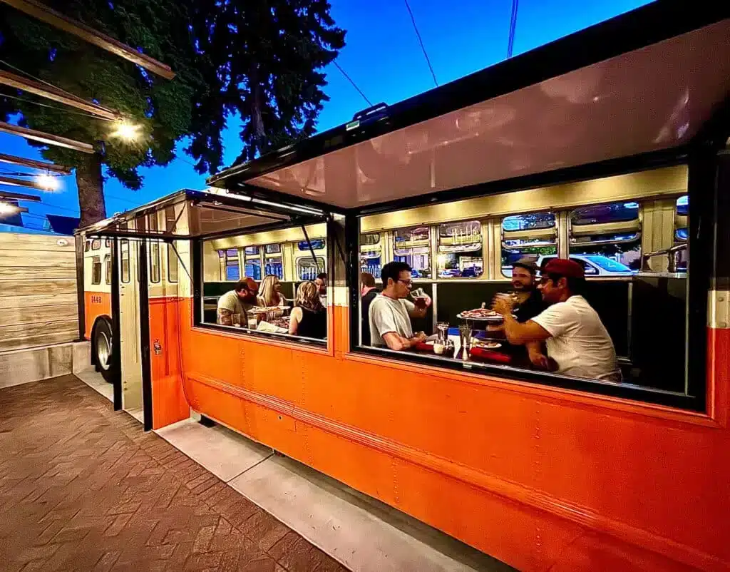 Friends sharing a plate of pizza at Transfer Pizzeria Cafe in Milwaukee