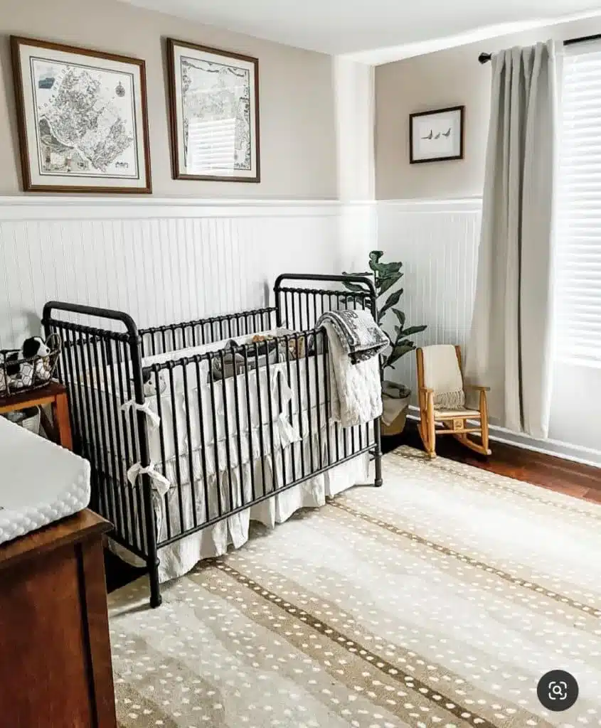 Travel modern gender-neutral nursery with black crib and white wainscoting