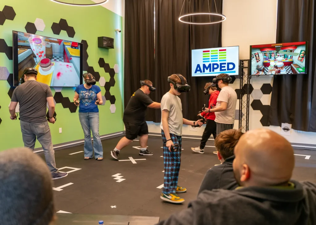 People of all ages wear VR equipment on their head at True Echo VR at 3rd Street Market Hall in Milwaukee.