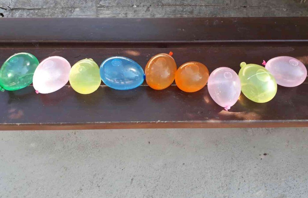 Nine colrful balloons filled with water to use during a birthday party
