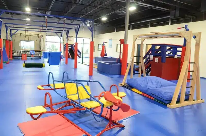 A play gym with colofrul equipmwent such as swings, monkeybars and boxes