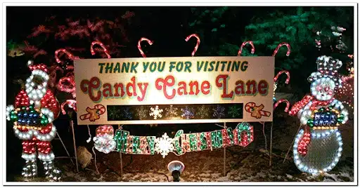 A poster that says Thank you for visiting Candy Cane Lane with Christmas themed decor.