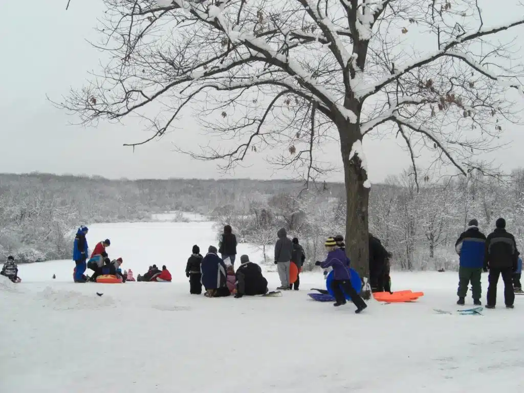 Families gathered at the top of Whitnall Park sledding hill