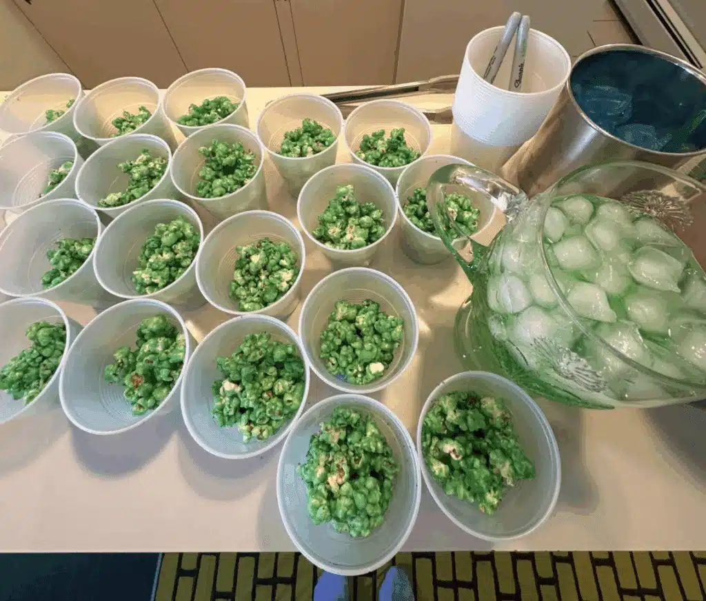 Green popcorn, blue ice cubes, and green-colored sprite, with a yellow brick road in the background.