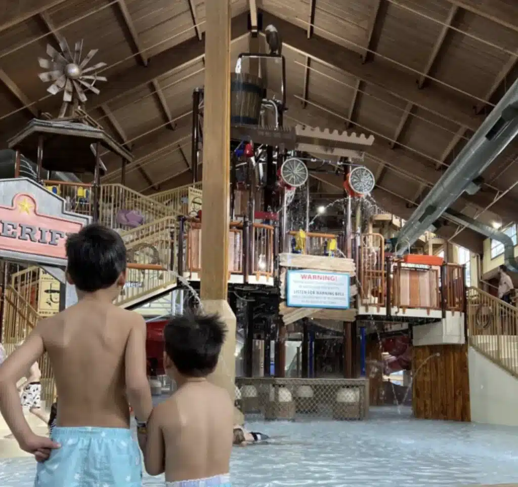 Two young children watching the large play structure at the Wild West Waterpark in Wisconsin Dells.
