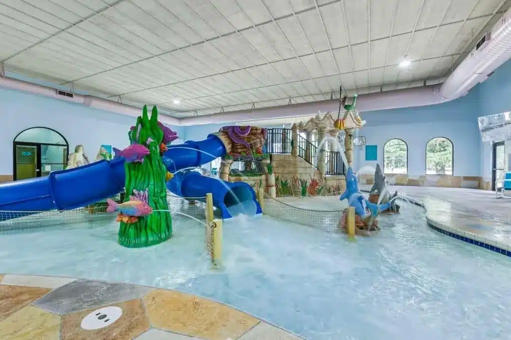 Indoor pool with shallow water and play features for young children at Atlantis Water Park Hotel in Wisconsin Dells
