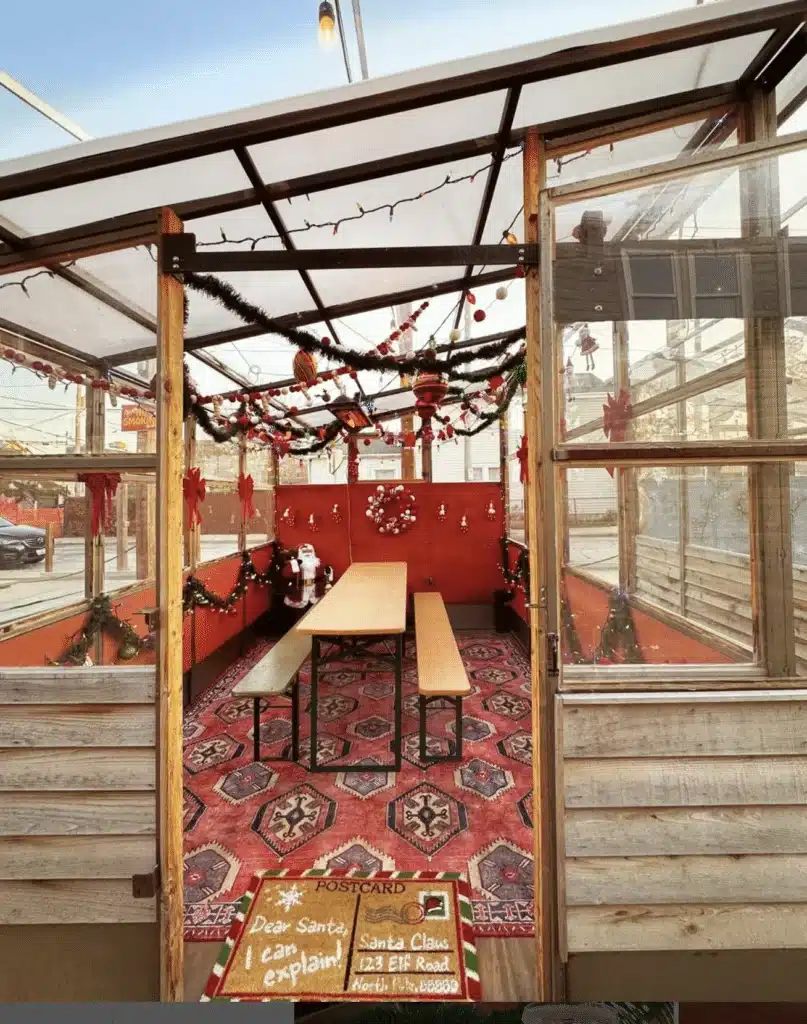 One of the dining areas at Zocalo Food Truck Park with lights hanging on the ceiling and Christmas garland on the walls.